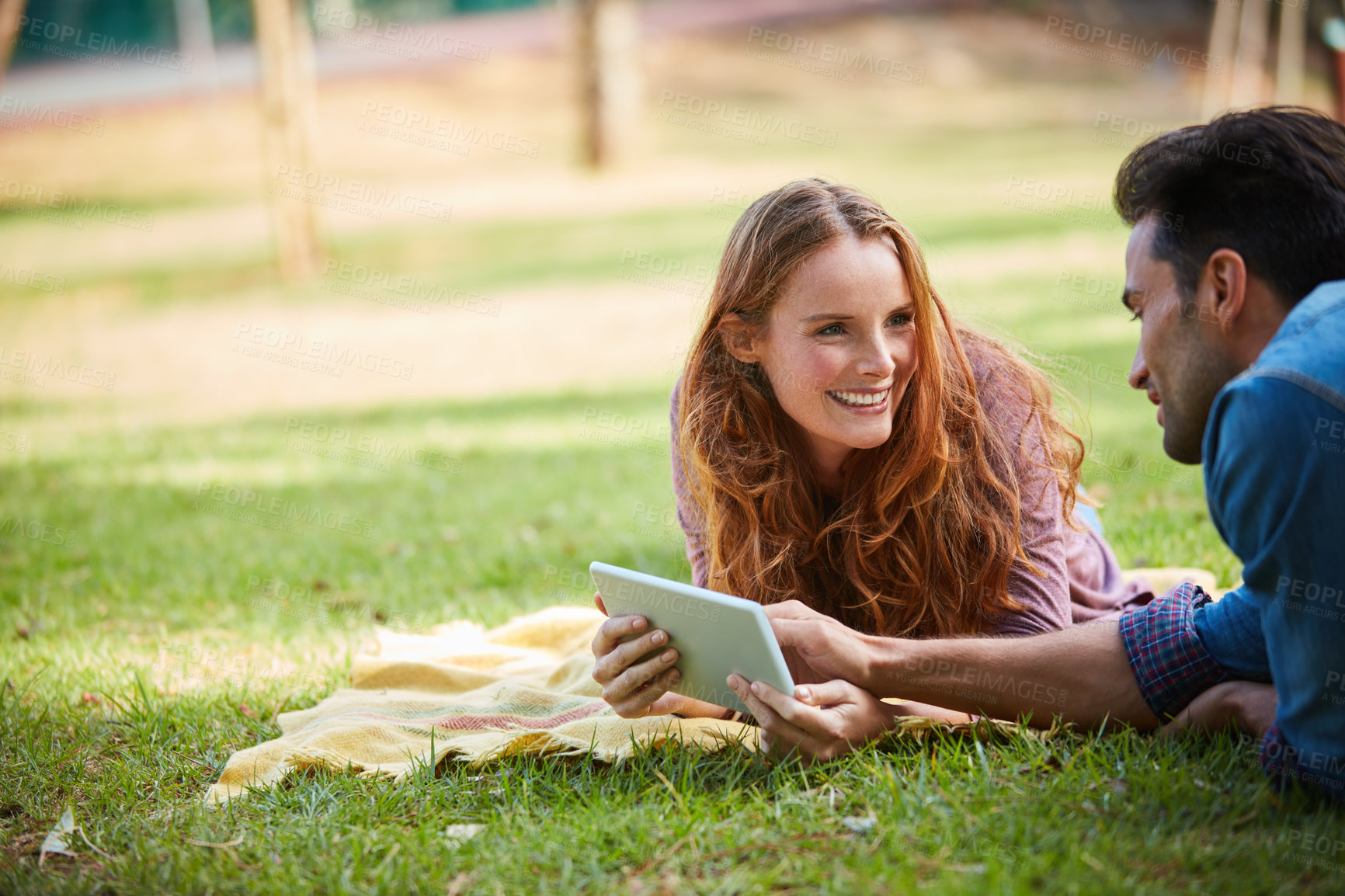 Buy stock photo Park, picnic and happy couple relax with tablet, search or streaming social media, video or reel in nature. Digital, app or people chilling on blanket with online sign up subscription for travel date