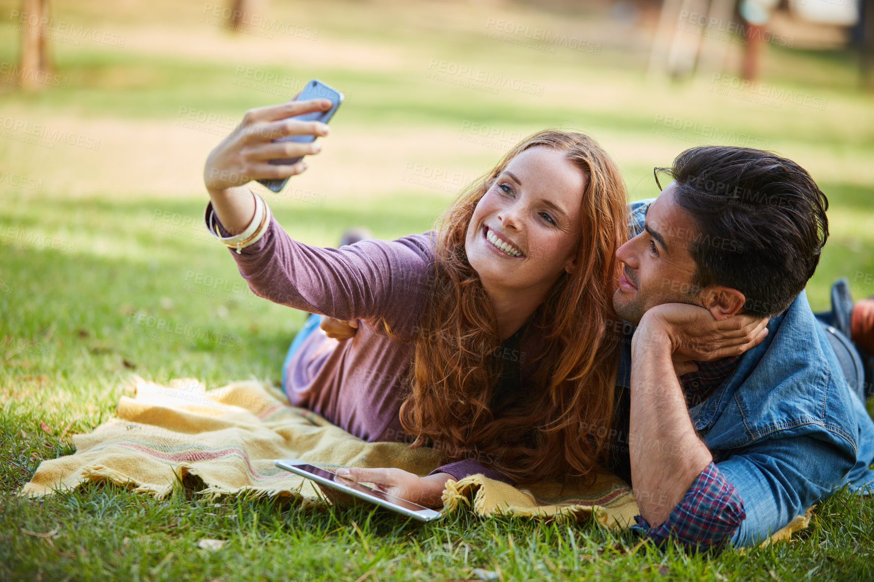Buy stock photo Picnic, selfie and happy couple in park relax with love, bonding and social media, profile picture or memory. Forest, date and influencer with smartphone photography for travel blog content in Canada