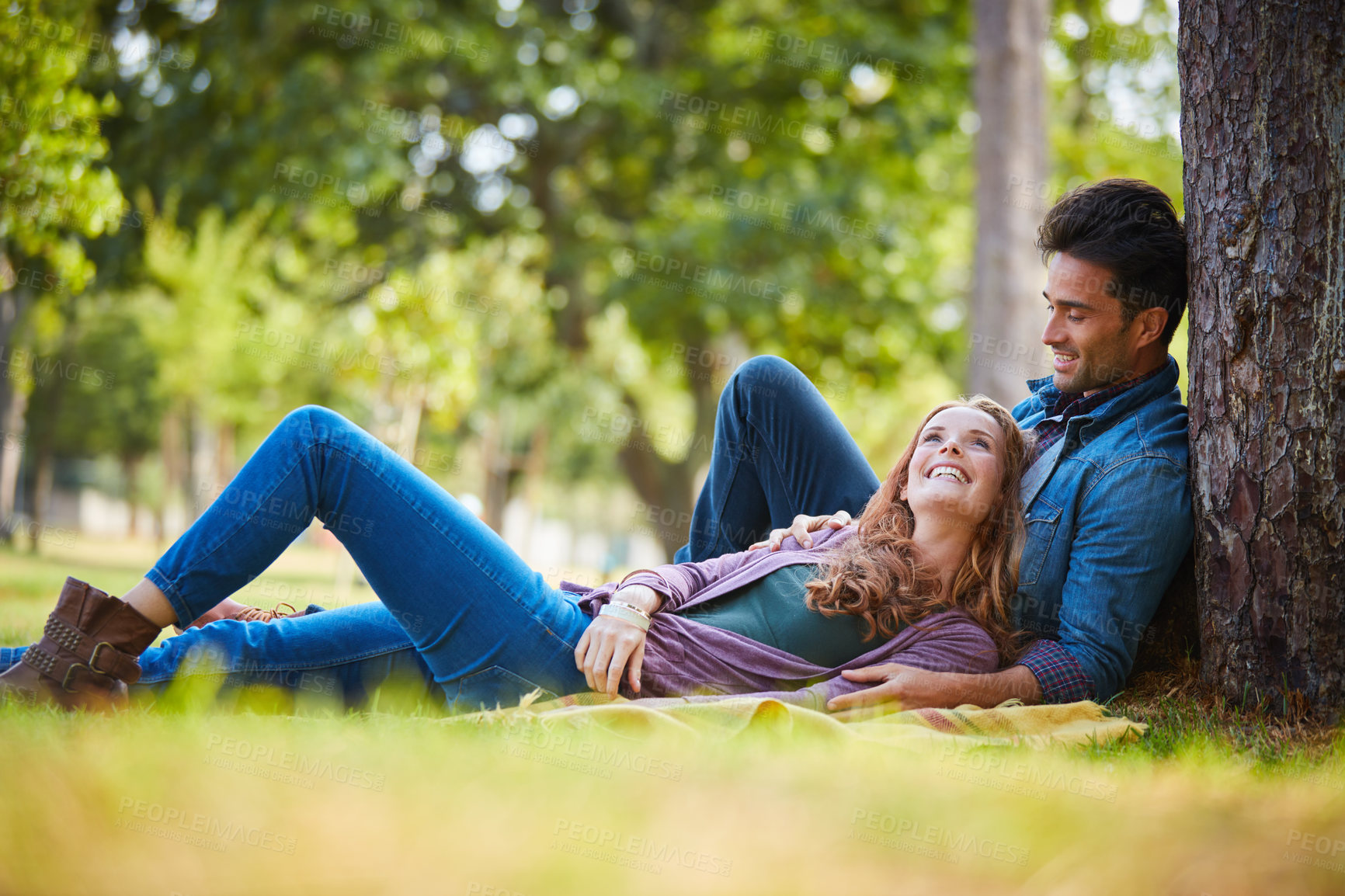 Buy stock photo Shot of a smiling young couple enjoying the day together at the park