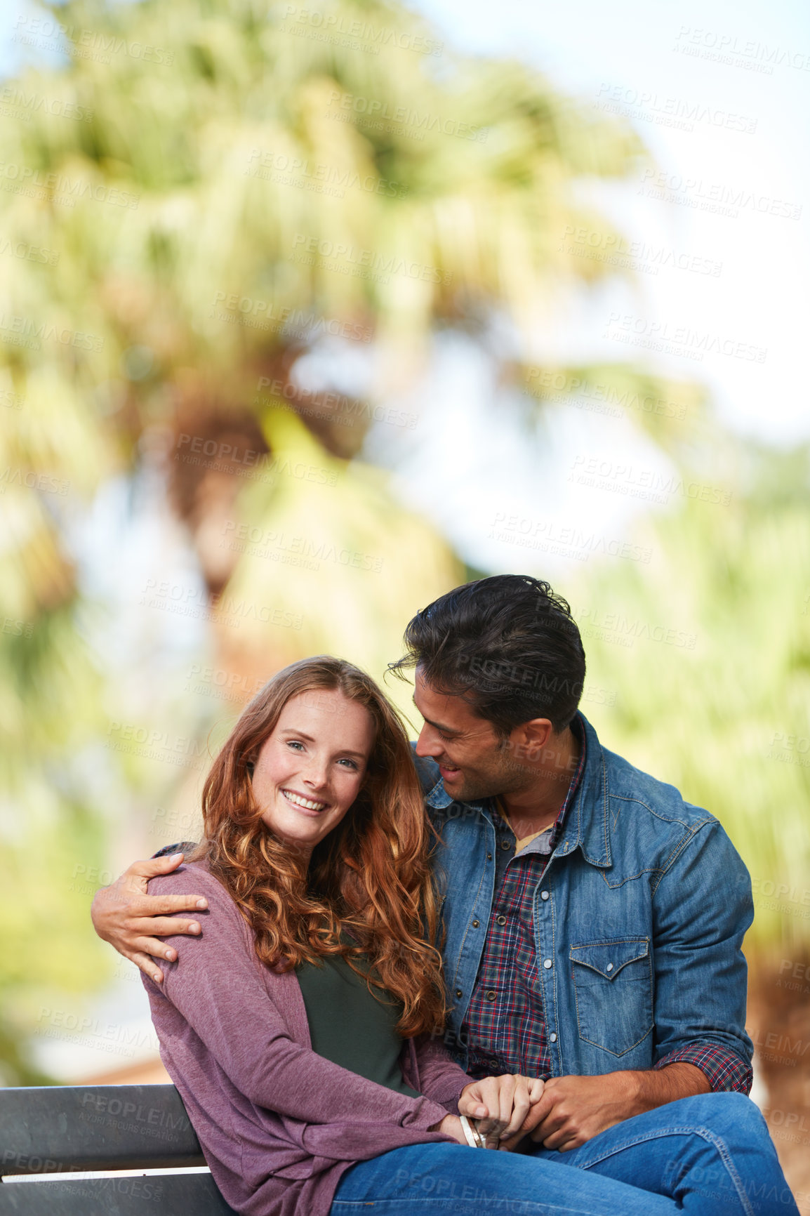 Buy stock photo Shot of a smiling young couple enjoying the day together at the park