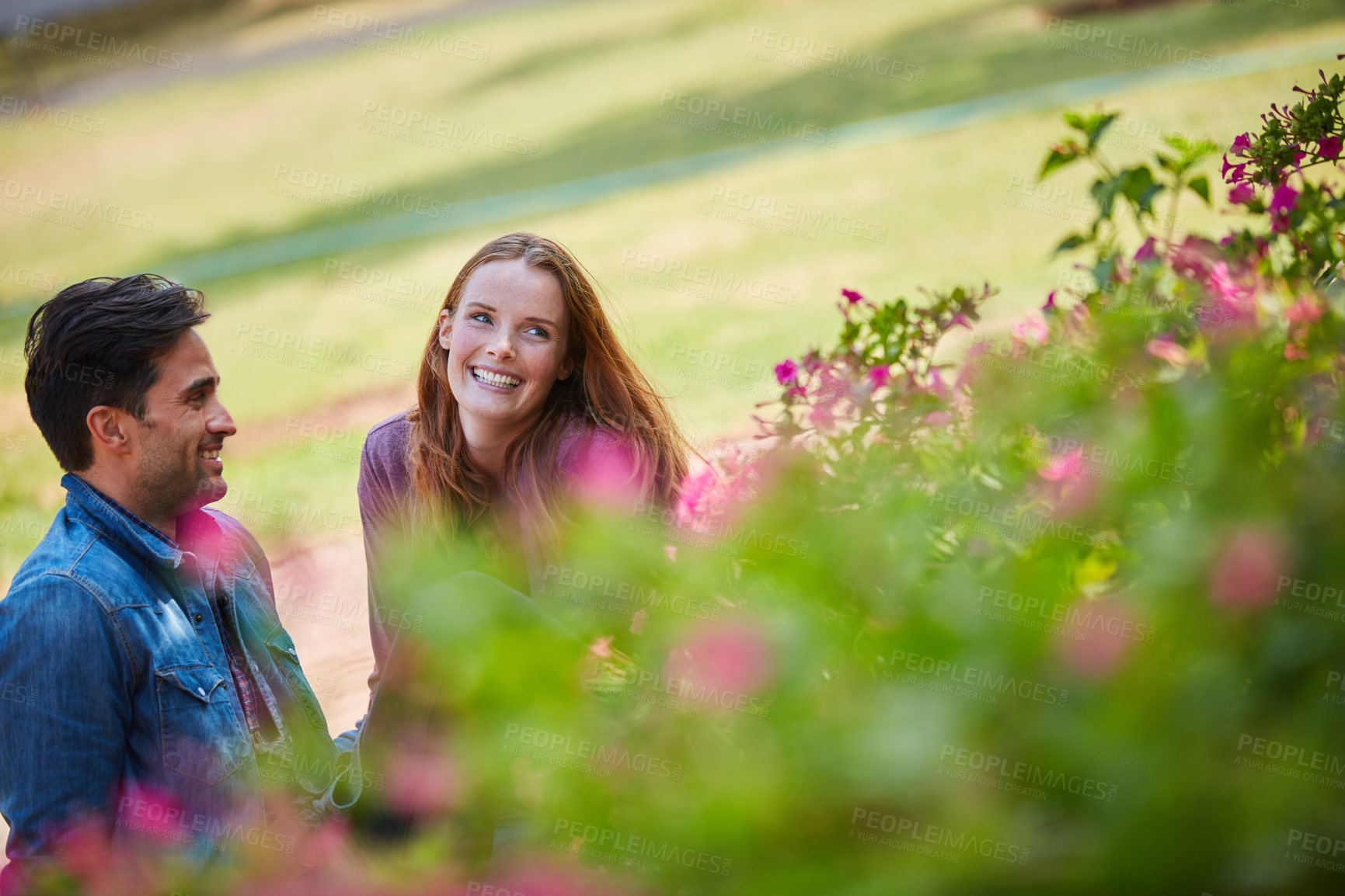 Buy stock photo Shot of a smiling young couple enjoying the day together at the park