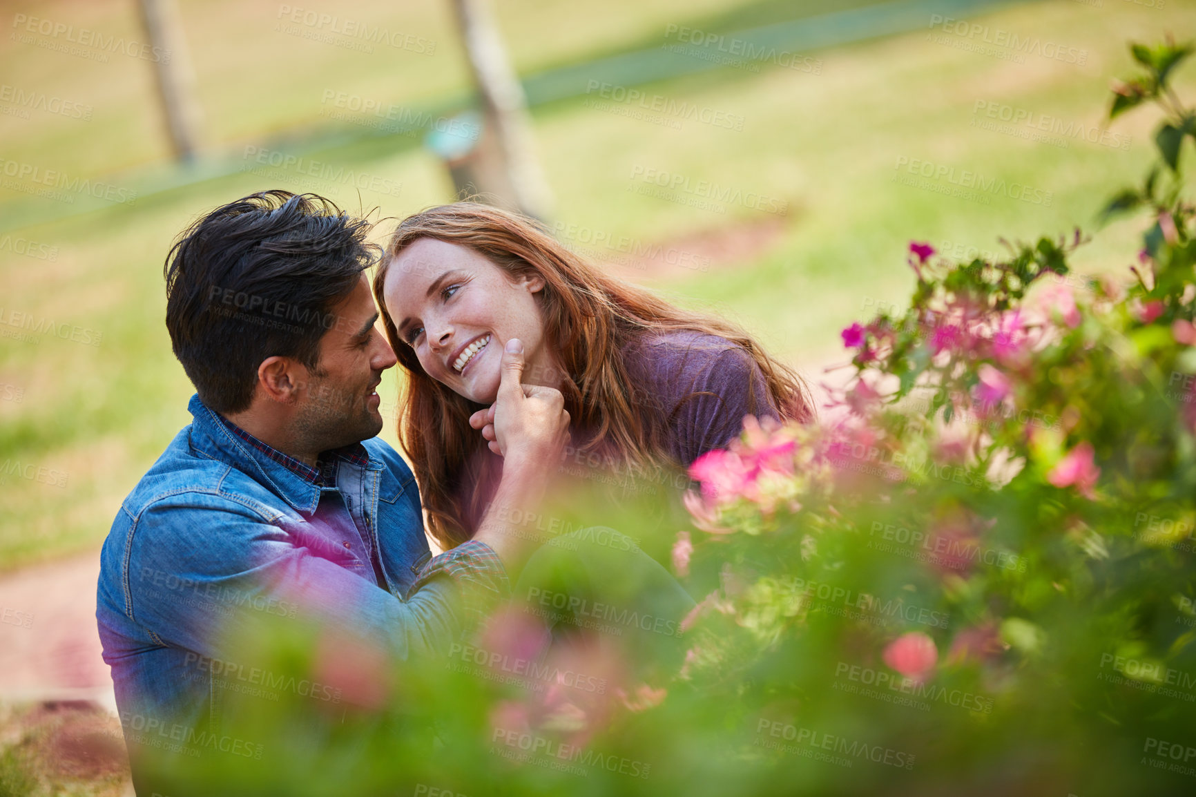 Buy stock photo Shot of a smiling young couple enjoying the day together at the park