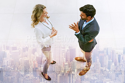 Buy stock photo Multiple exposure shot of two businesspeople having a discussion superimposed over a cityscape