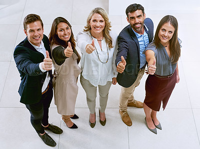 Buy stock photo Portrait of a group of businesspeople showing thumbs up together in an office