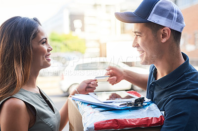 Buy stock photo Cropped shot of a businesswoman using a credit card to pay for a delivery made by a courier