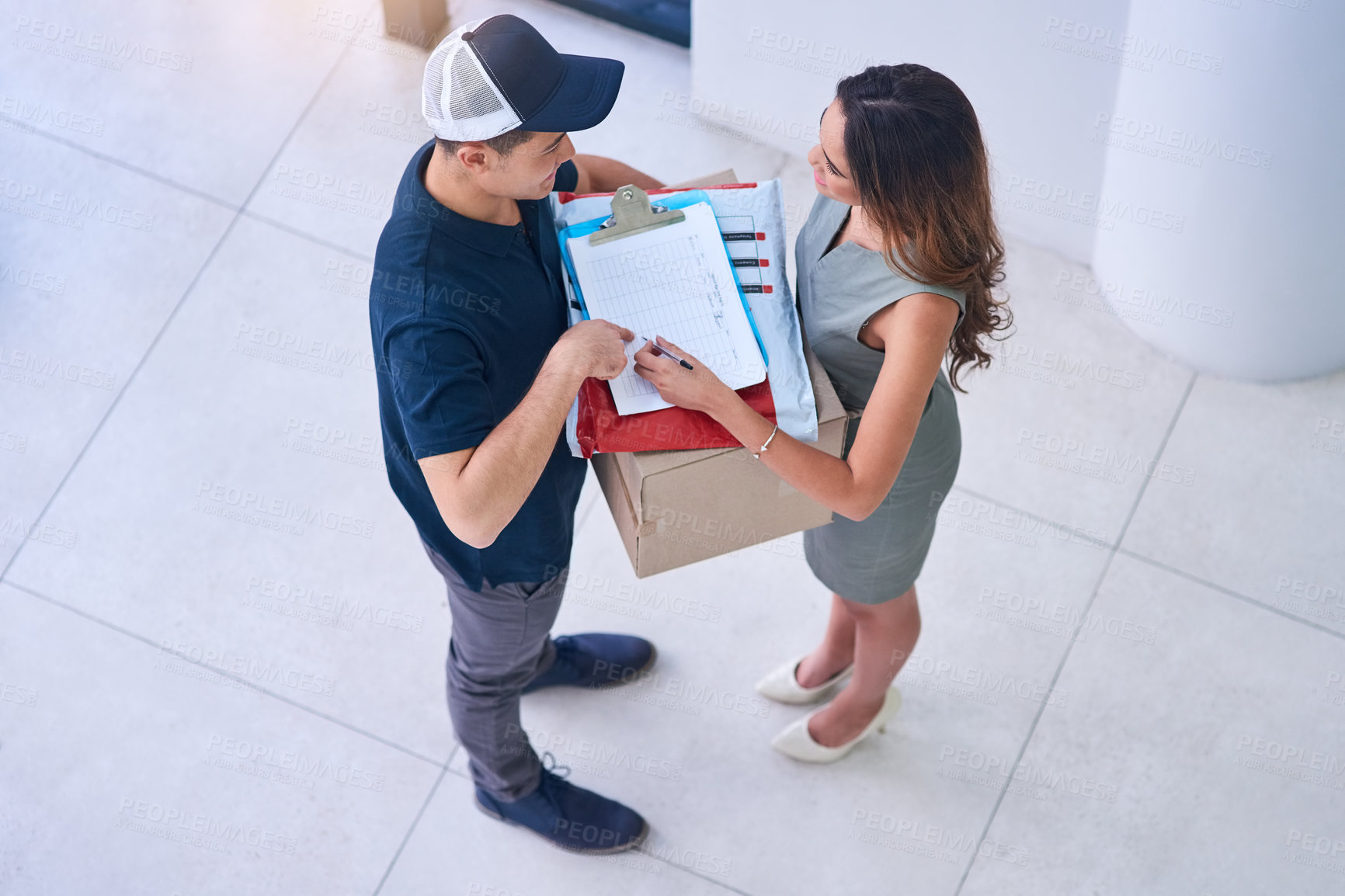 Buy stock photo Shot of a courier making a delivery to a businesswoman in an office