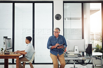 Buy stock photo Shot of two male designers working individually in their office