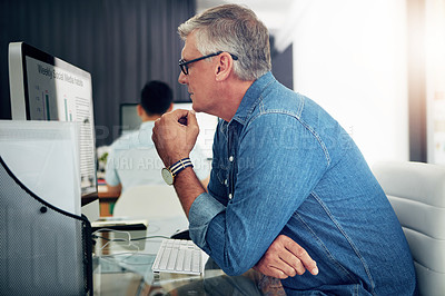 Buy stock photo Cropped shot of a mature businessman working on his designs in the office
