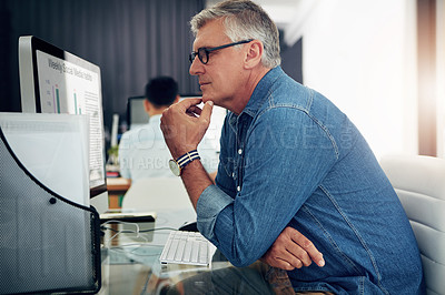 Buy stock photo Cropped shot of a mature businessman working on his designs in the office