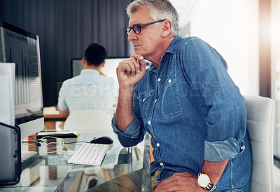 Buy stock photo Cropped shot of a mature businessman working on his designs in the office