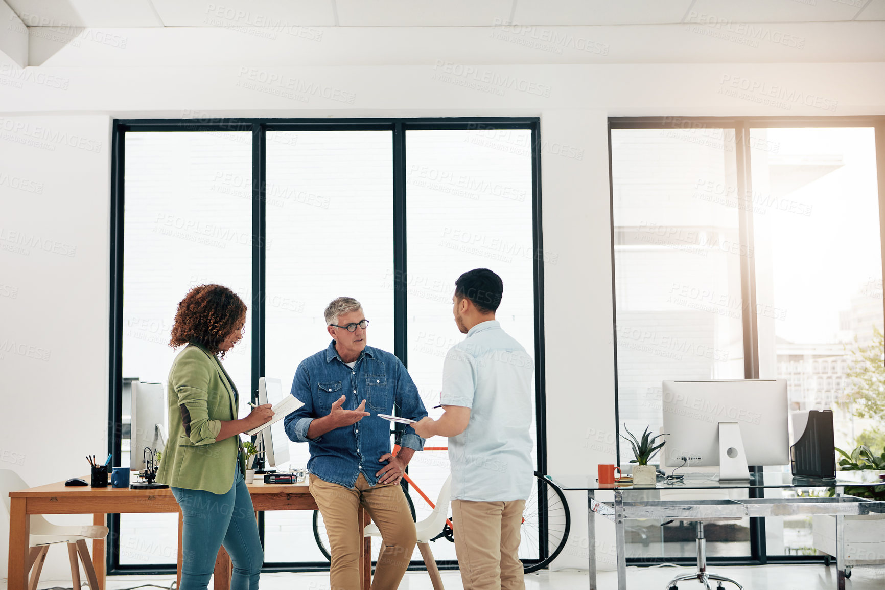 Buy stock photo Cropped shot of three creative professionals talking in the office