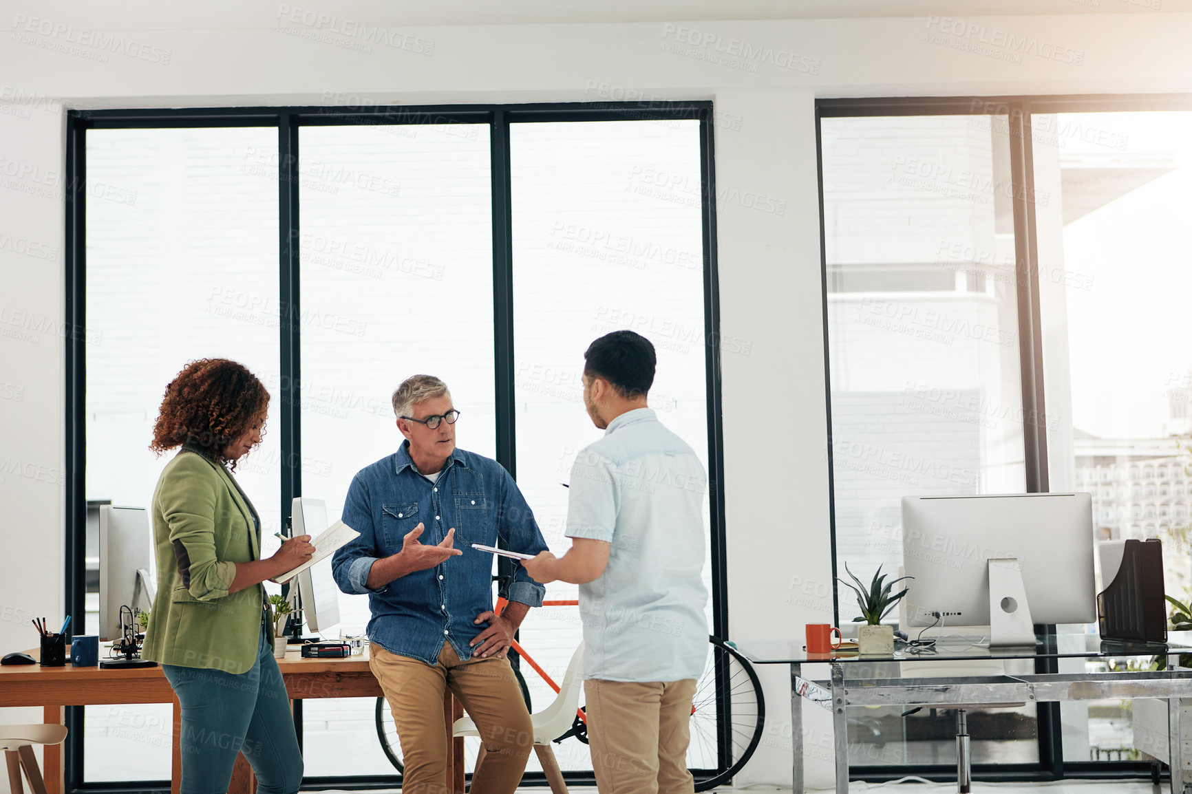 Buy stock photo Cropped shot of three creative professionals talking in the office