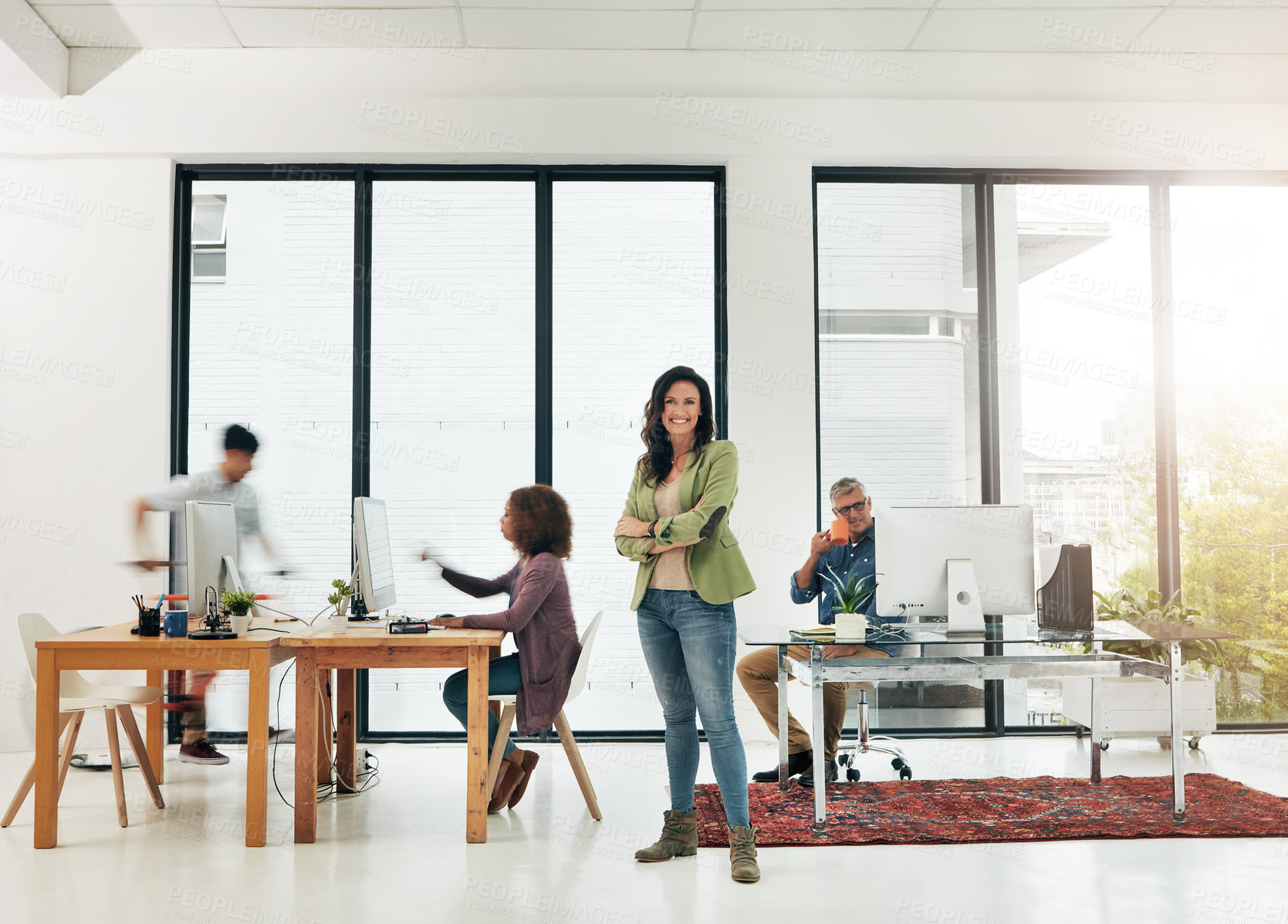 Buy stock photo Portrait of a young designer standing in the office with her colleagues in the background