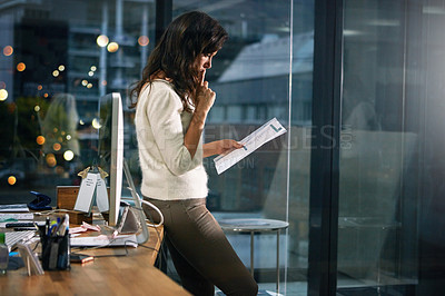 Buy stock photo Shot of a dedicated businesswoman working alone in her office after hours