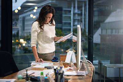 Buy stock photo Shot of a dedicated businesswoman working alone in her office after hours