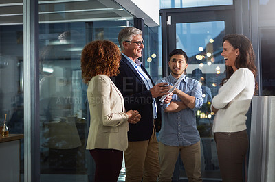 Buy stock photo Shot of a team of dedicated colleagues working together in their office after hours