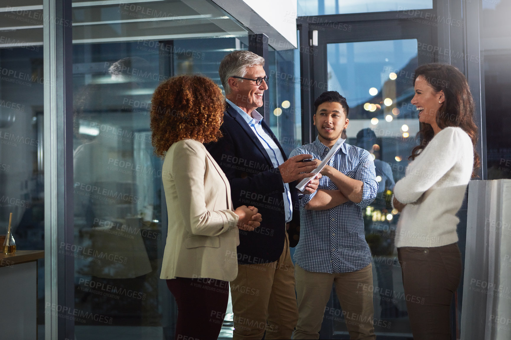 Buy stock photo Shot of a team of dedicated colleagues working together in their office after hours