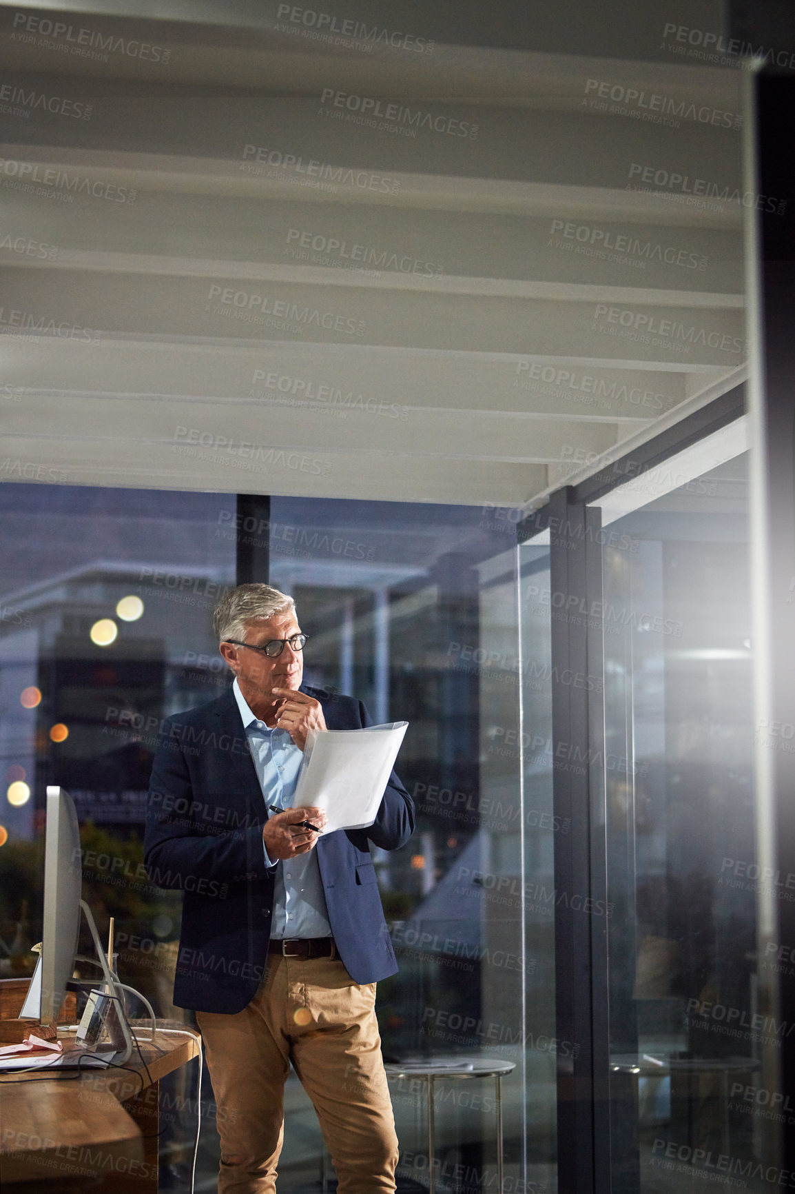 Buy stock photo Shot of a dedicated businessman working alone in his office after hours