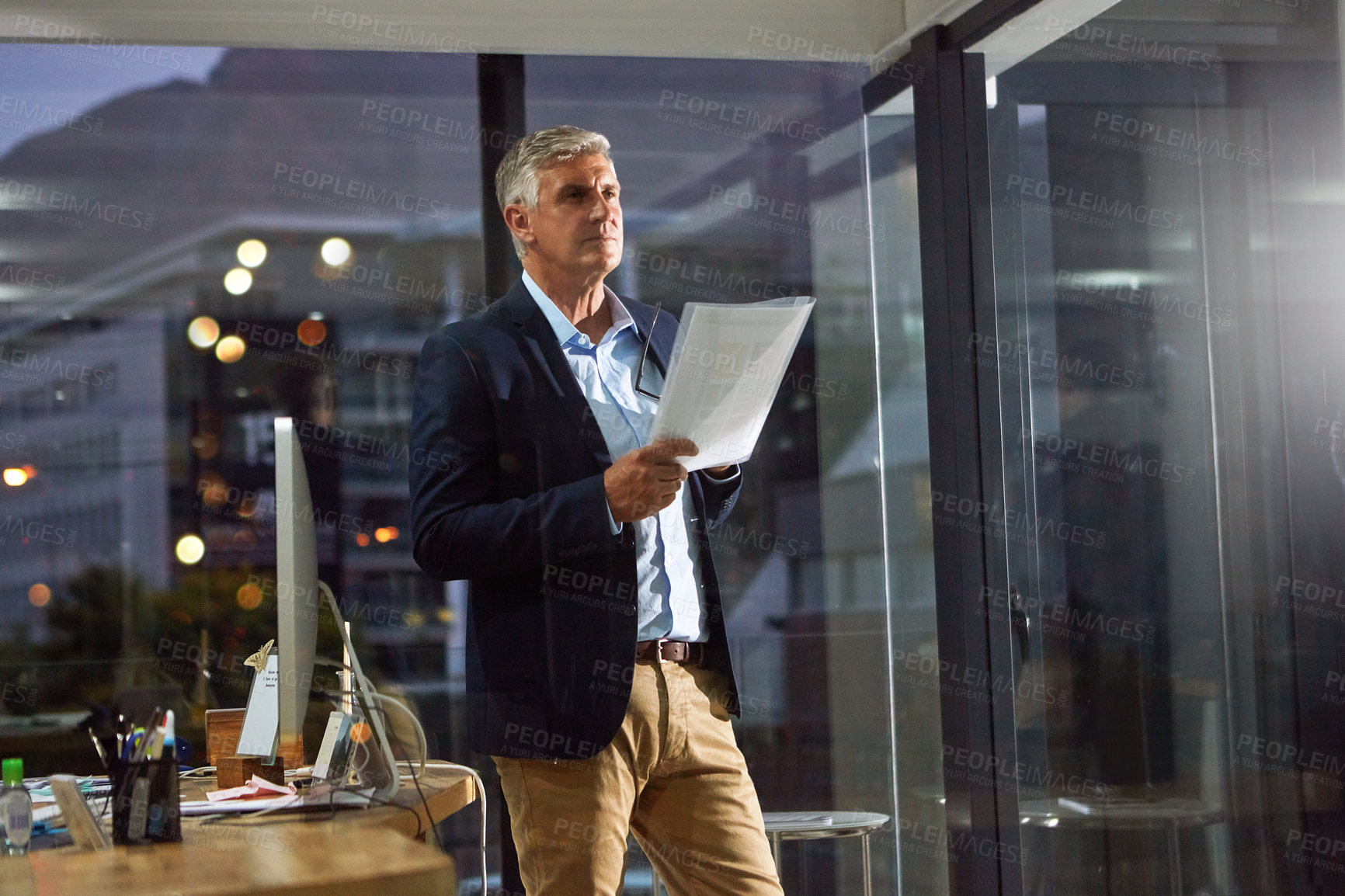 Buy stock photo Shot of a dedicated businessman working alone in his office after hours