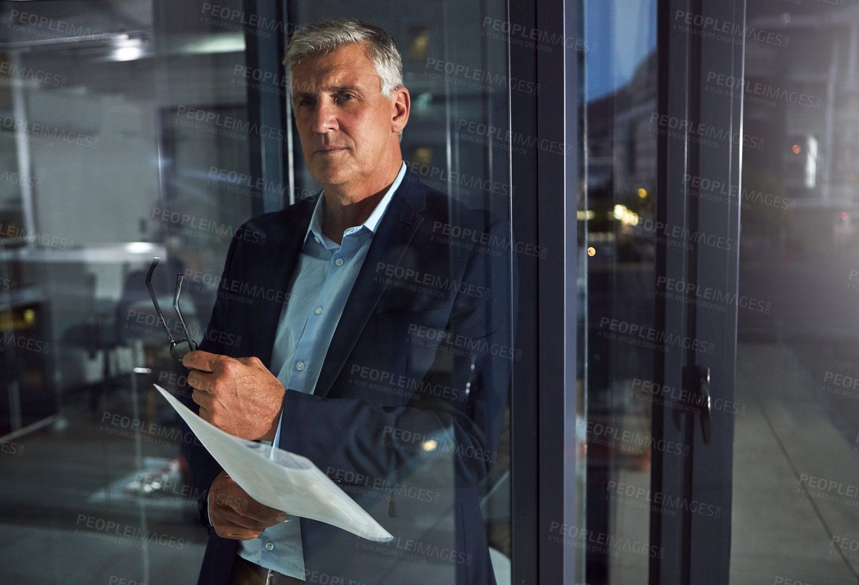 Buy stock photo Shot of a dedicated businessman working alone in his office after hours