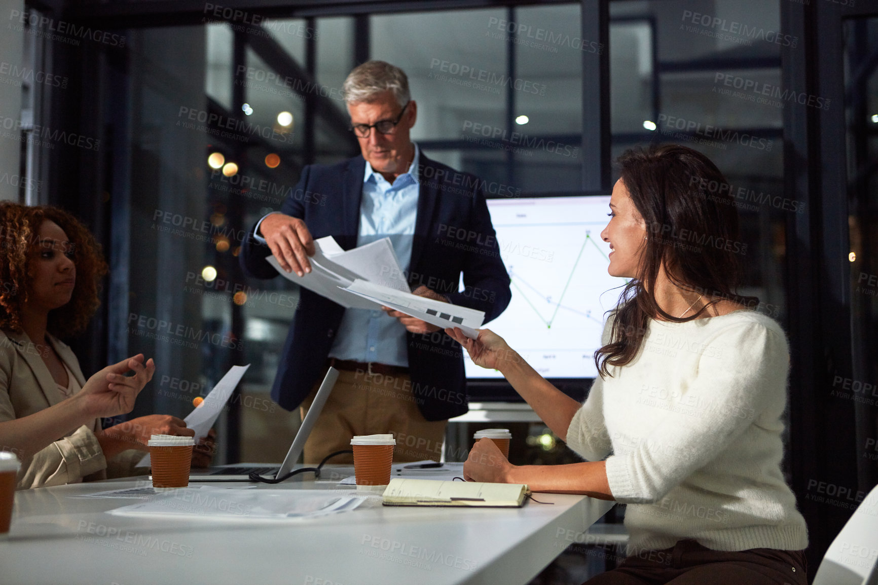 Buy stock photo Shot of a dedicated businessman giving a presentation to his colleagues in the boardroom after hours