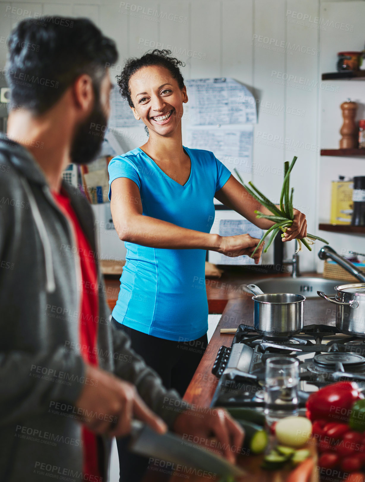 Buy stock photo Shot of a happy couple cooking together in their kitchen at home