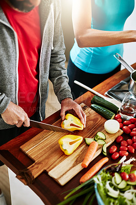 Buy stock photo High angle shot of an unidentifiable couple cooking together in their kitchen at home