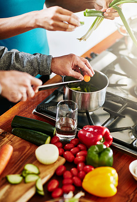 Buy stock photo High angle shot of an unidentifiable couple cooking together in their kitchen at home