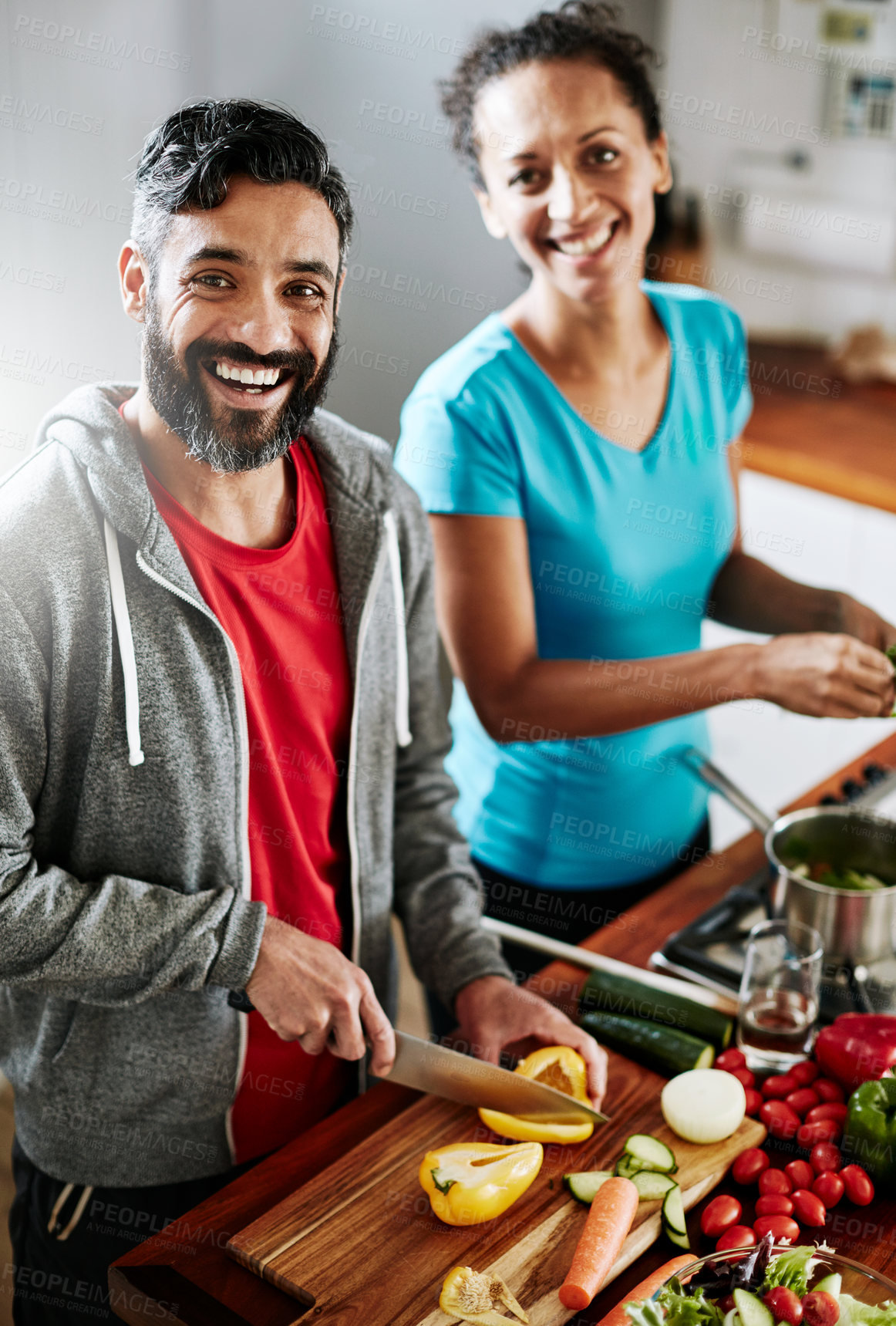 Buy stock photo Portrait of a happy couple cooking together in their kitchen at home