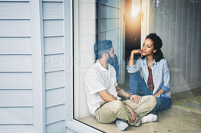 Buy stock photo Couple, relax and talking while sitting by window enjoying morning or day together on floor at home. Man and woman relaxing in relationship, discussion or conversation for weekend or holiday indoors