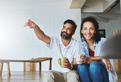Buy stock photo Couple, home and coffee for relax with point, calm and morning smile in living room. Love, house and laugh for man and female person in step, together and support or unity with tea or drink in lounge