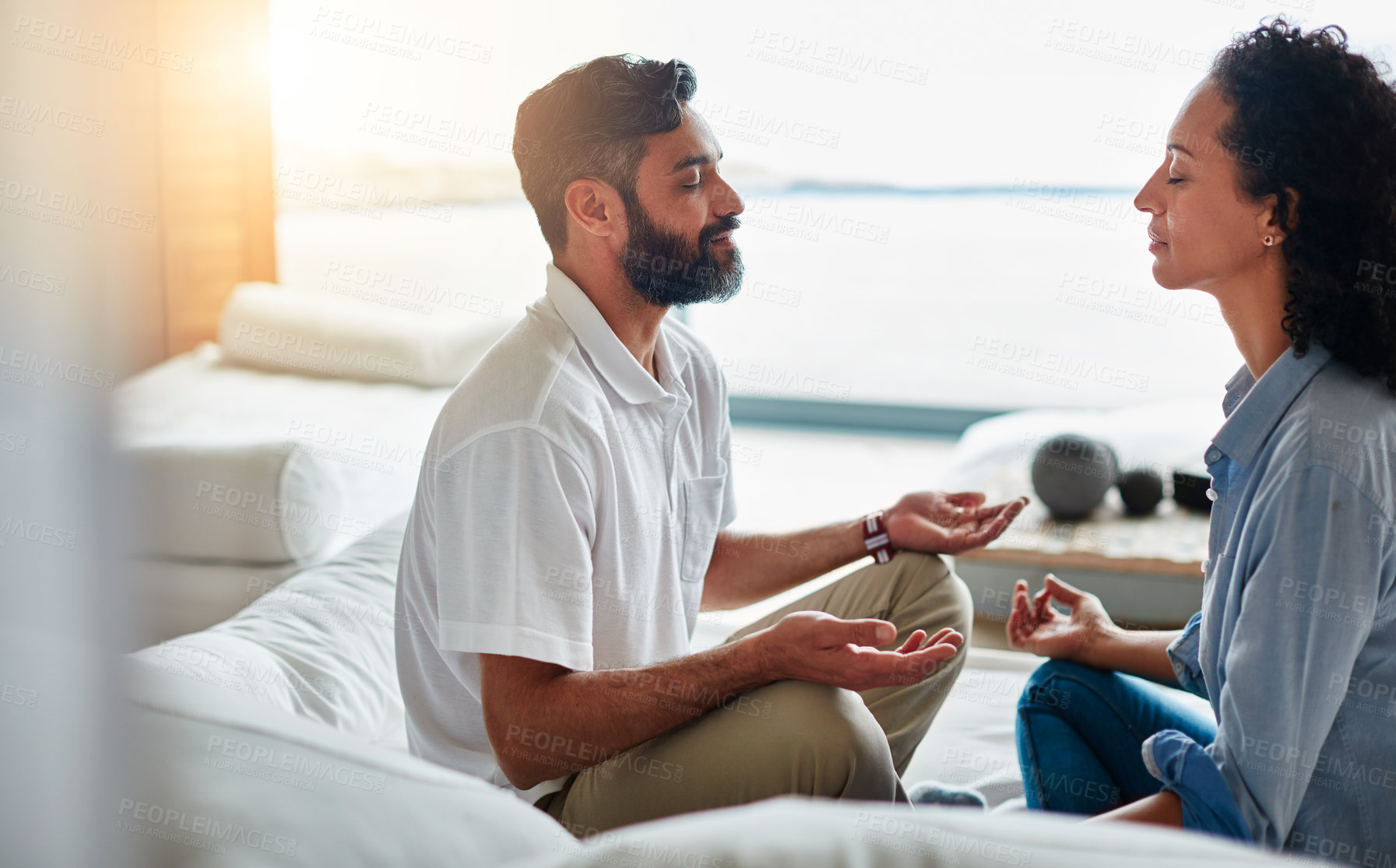 Buy stock photo Shot of a relaxed couple meditating together at home