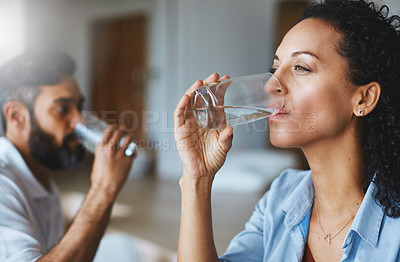 Buy stock photo Shot of a couple drinking glasses of water together at home