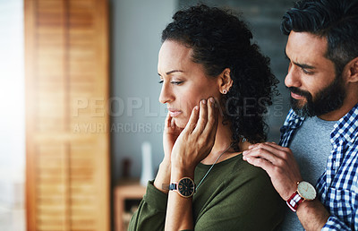Buy stock photo Shot of a man comforting his distraught wife at home