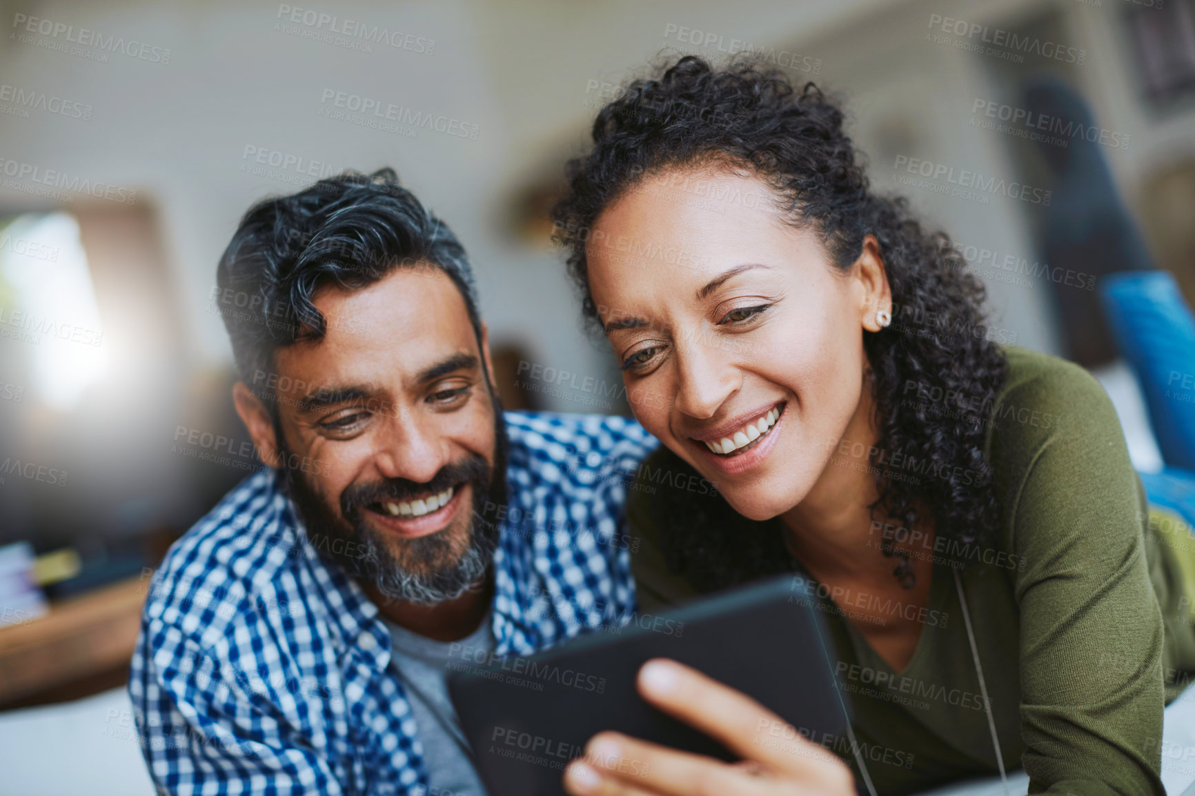 Buy stock photo Shot of a laid-back couple relaxing with wireless technology at home