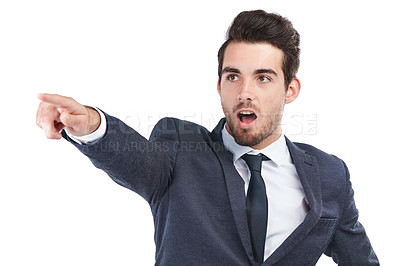 Buy stock photo Studio shot of a young businessman pointing towards something against a white background