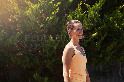Buy stock photo Shot of a happy woman out for a run in her neighborhood