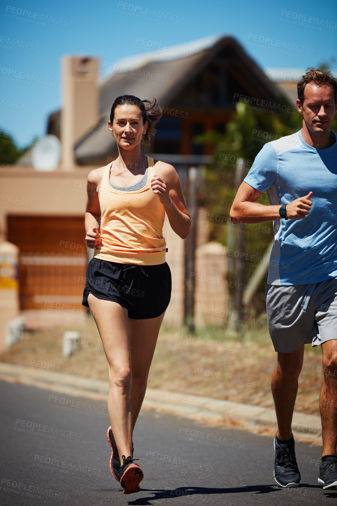 Buy stock photo Shot of a happy couple jogging together in their neighborhood