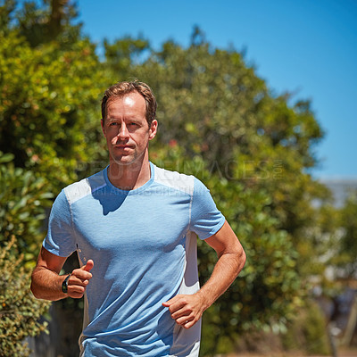 Buy stock photo Shot of a carefree man out for a run in his neighborhood