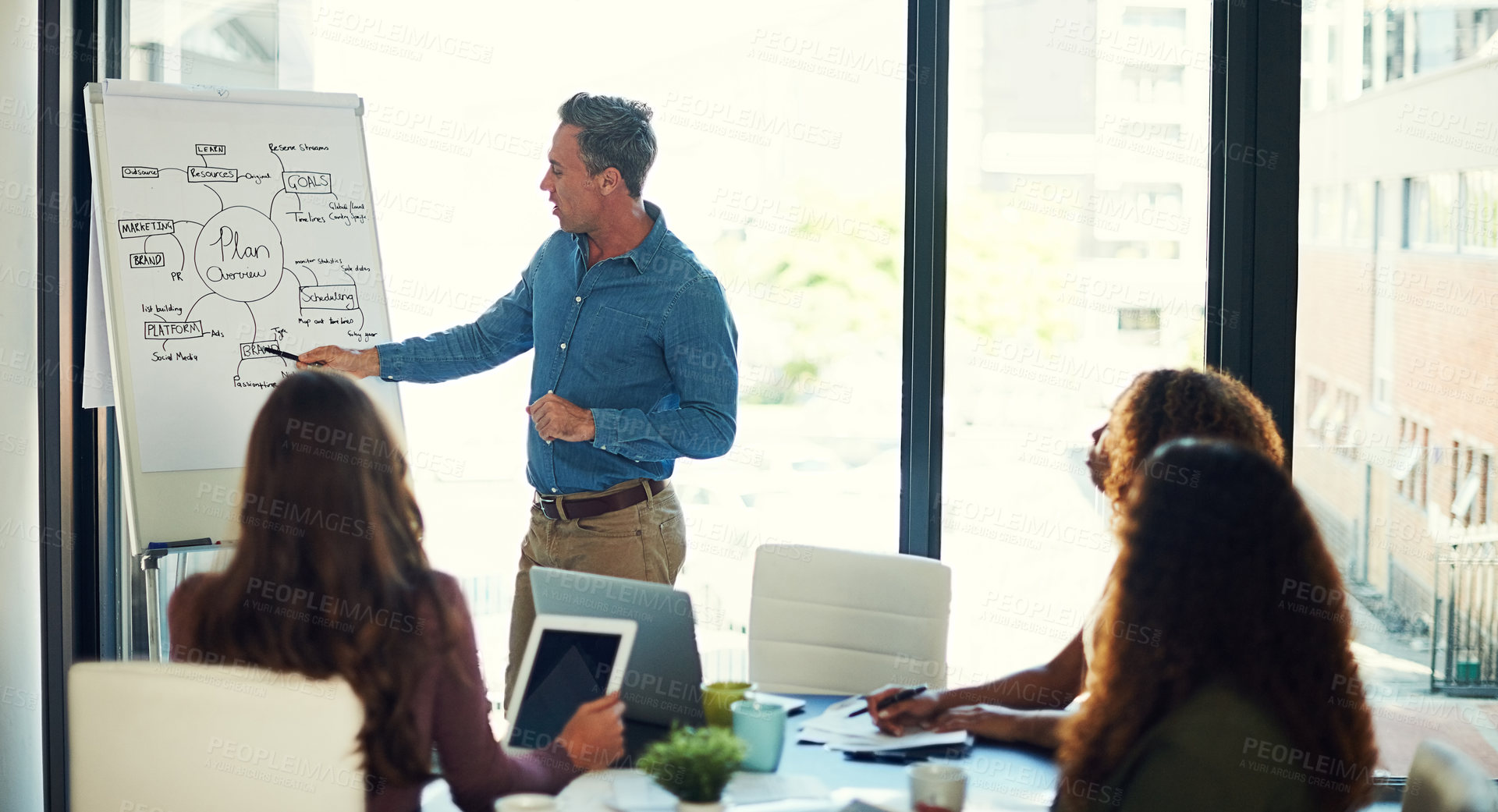 Buy stock photo Cropped shot of a mature businessman giving a presentation to his colleagues in a boardroom