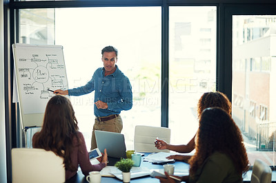 Buy stock photo Cropped shot of a mature businessman giving a presentation to his colleagues in a boardroom