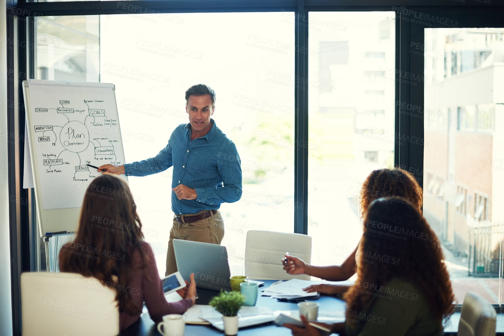 Buy stock photo Cropped shot of a mature businessman giving a presentation to his colleagues in a boardroom