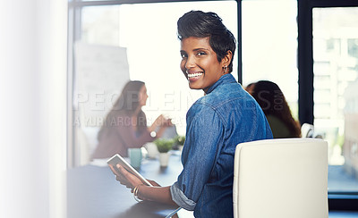 Buy stock photo Portrait of a young businesswoman working on a digital tablet with her colleagues in the background