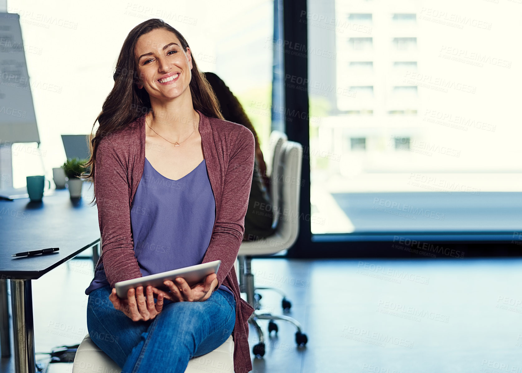 Buy stock photo Portrait of a young businesswoman working on a digital tablet with her colleagues in the background