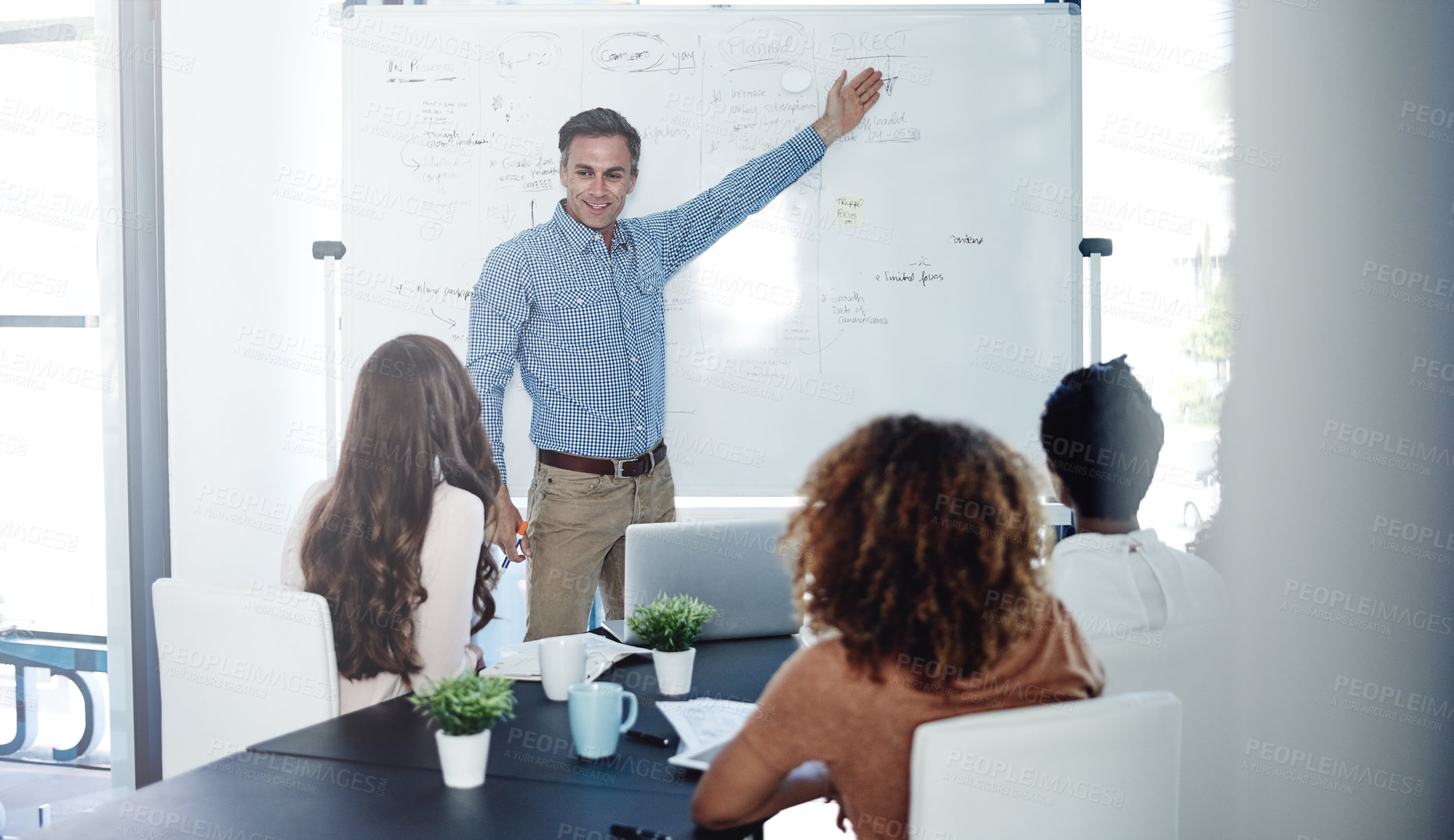 Buy stock photo Shot of a businessman delivering a presentation to his colleagues in a boardroom meeting