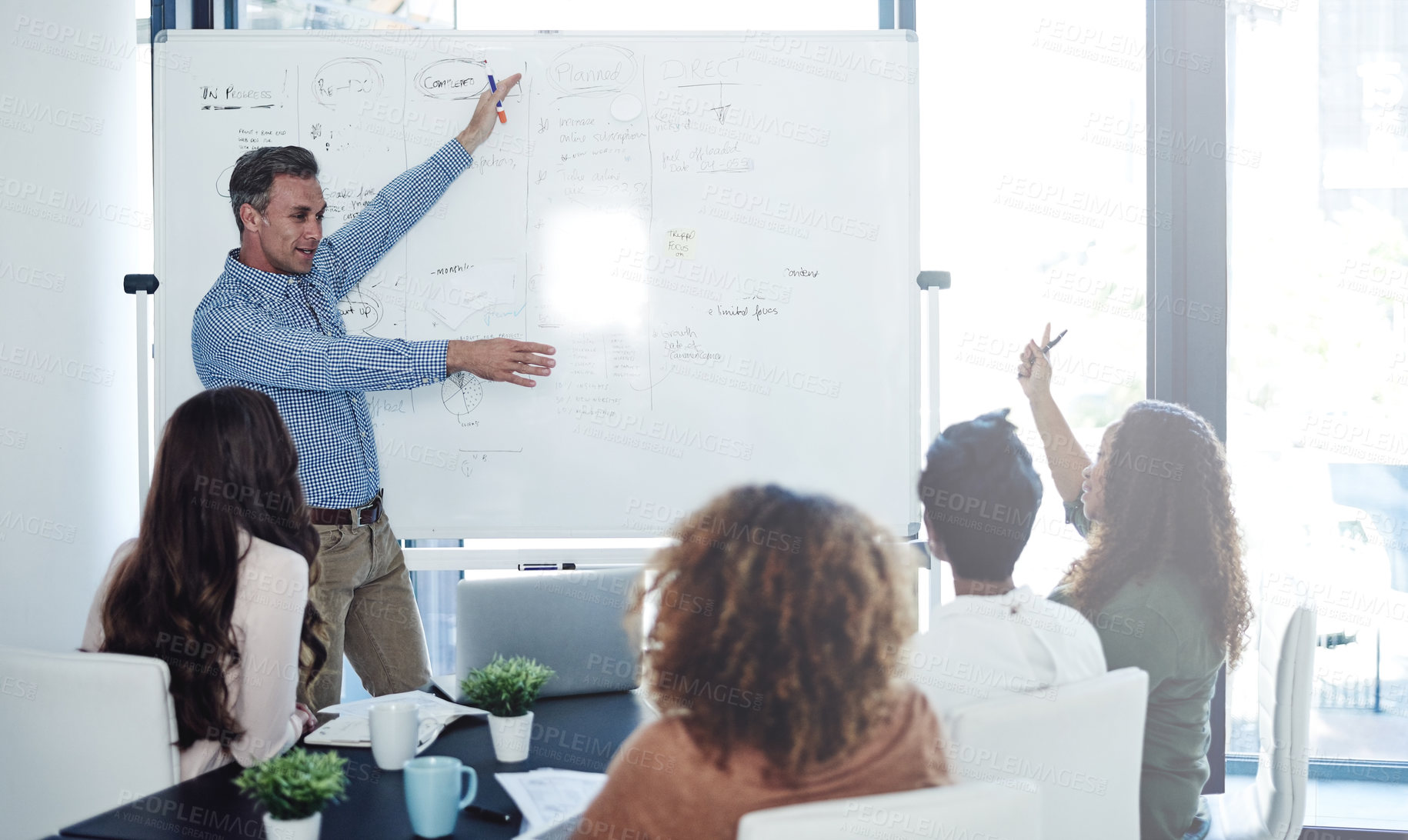 Buy stock photo Shot of a businessman delivering a presentation to his colleagues in a boardroom meeting