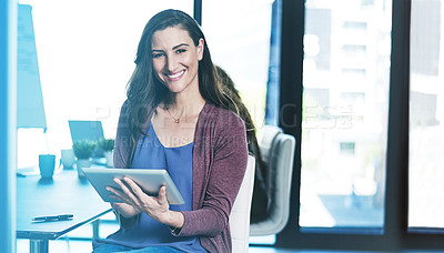 Buy stock photo Shot of a businesswoman using a digital tablet while sitting in an office