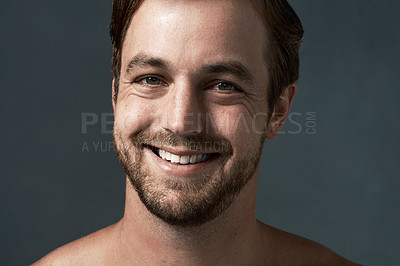 Buy stock photo Man, portrait and smile for skincare in studio, confidence and beauty on blue background, Male person, happy and cosmetics for facial treatment or clean and smooth skin, dermatology and proud health