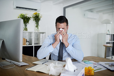 Buy stock photo Shot of a young businessman suffering with allergies at work