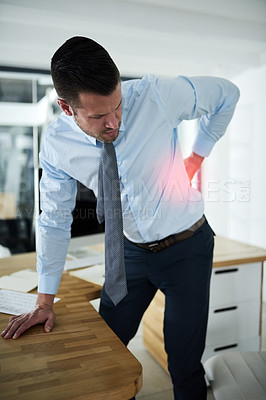 Buy stock photo Shot of a young businessman experiencing back pain highlighted in glowing red at work